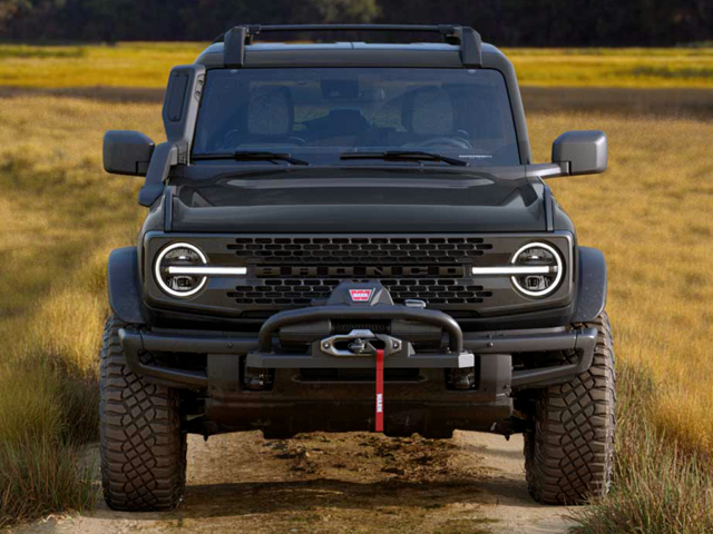 A black Ford Bronco raptor trim blazing a trail off-road and coming straight on towards the camera