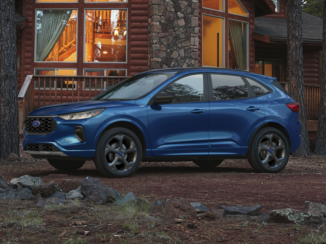 A metallic blue Ford Escape Platinum trim sitting in front of a quaint country cottage at dusk. 