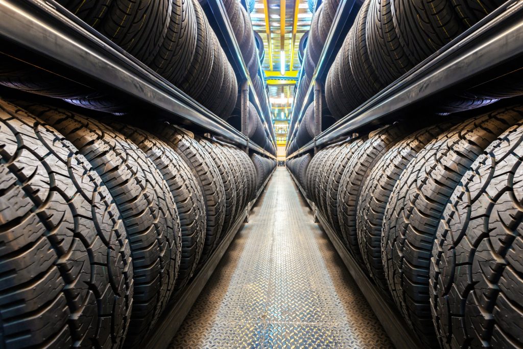 An image of a broad selection of tires looking down a row in a tire shop. 