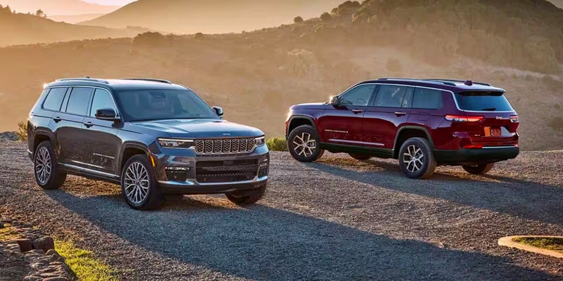 Two Jeep Grand Cherokee vehicles in an off-road setting at sunset. 